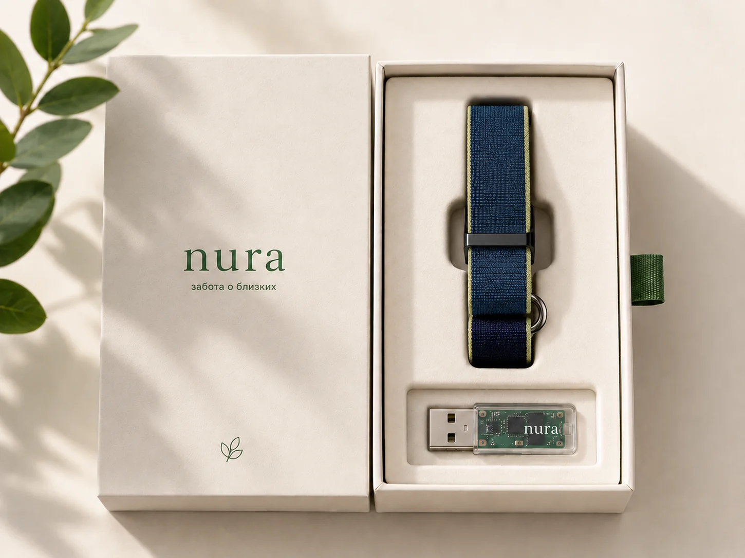 Открытая коробка Nura: внутри браслет с нейлоновым ремешком, силиконовый ремешок на замену и USB-адаптер